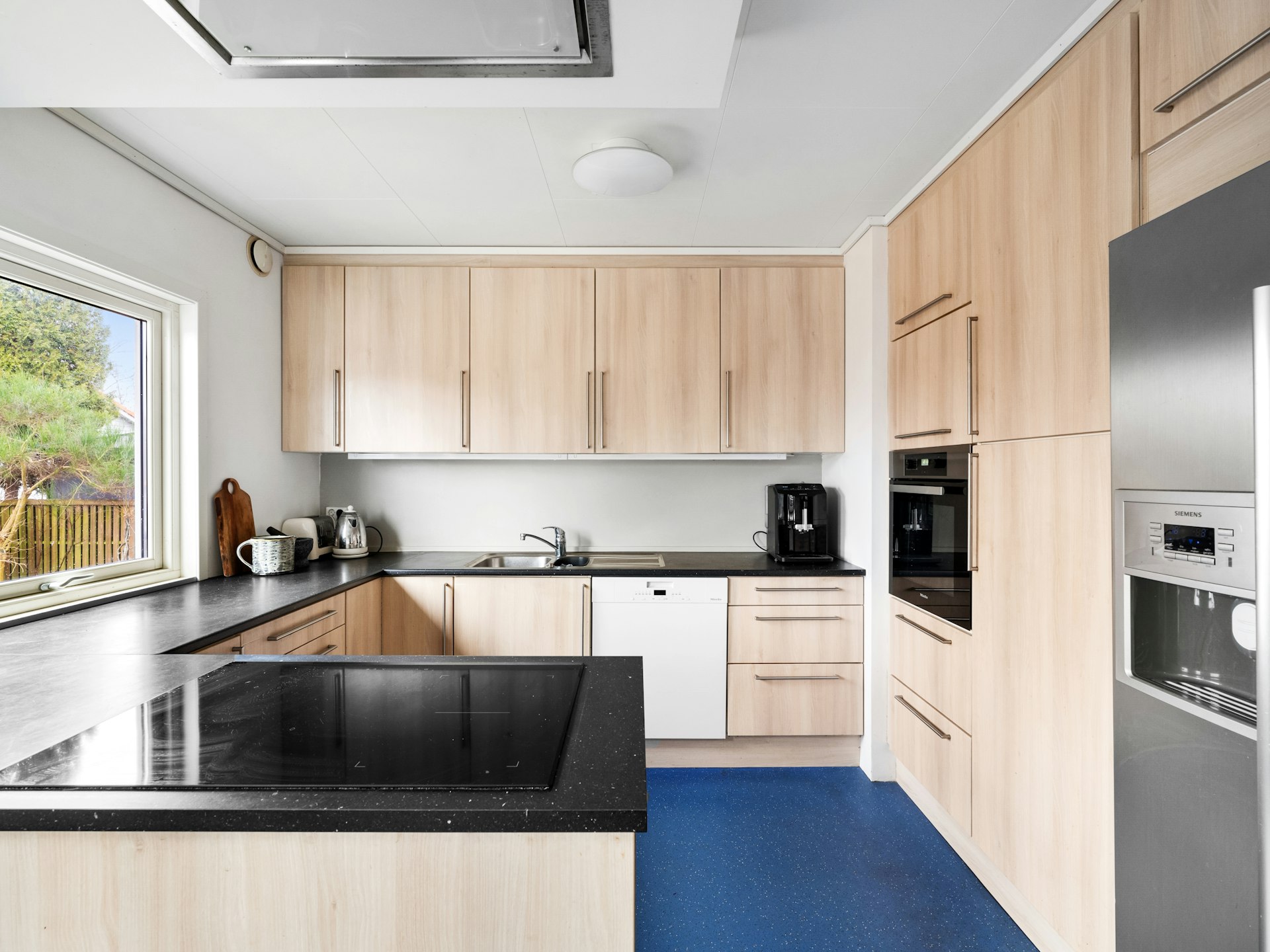 A kitchen with a blue floor and wooden cabinets